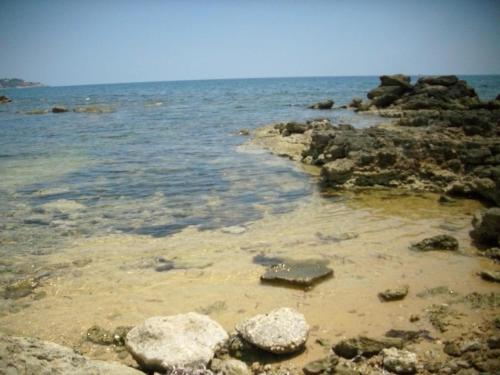 Villetta Mare في Terrauzza: شاطئ به بعض الصخور والماء