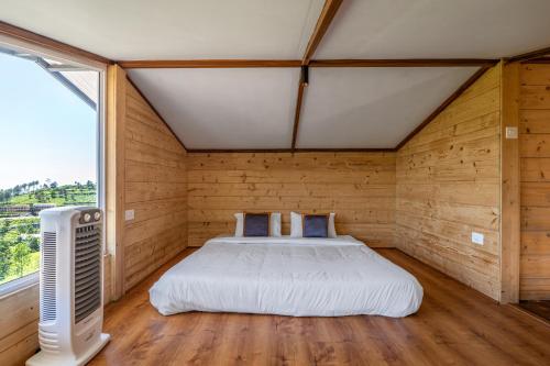 a bedroom with a bed in a room with a window at Wattle Grove Resort in Kotagiri