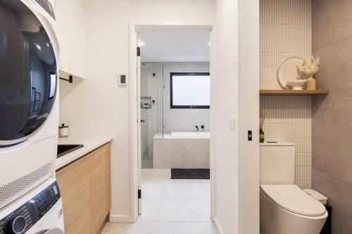 a bathroom with a toilet and a sink and a tub at Bayside Spritz in Hampton in Melbourne