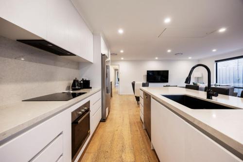 a kitchen with white counters and a sink at Bayside Spritz in Hampton in Melbourne