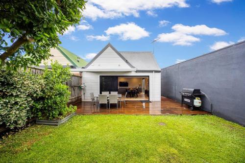 a backyard with a white house with a lawn at Bayside Spritz in Hampton in Melbourne