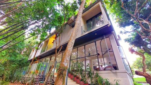 a building with a tree in front of it at Balishira Resort Ltd. in Sreemangal