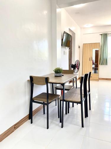 a dining room with a wooden table and chairs at Nedz Suites in Ocoy