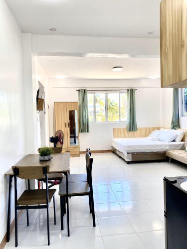 a kitchen and living room with a table and a bed at Nedz Suites in Ocoy