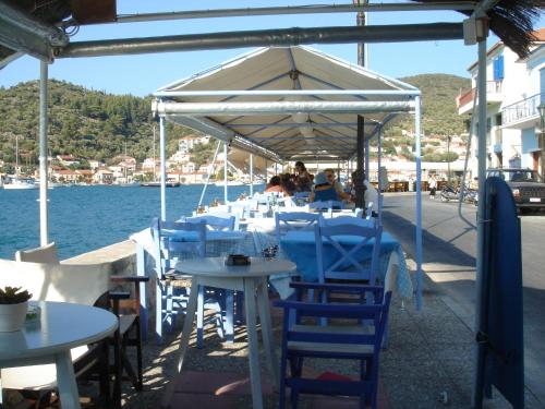 a group of tables and chairs under a tent on the water at Panorama in Vathi, Ithaka