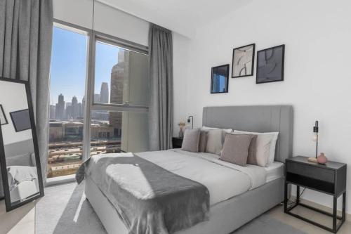 a bedroom with a large bed and a large window at New Stunning 4 BR Burj Khalifa View in Dubai
