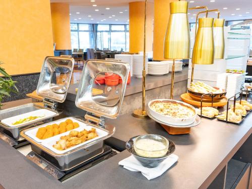 a buffet line with food on a counter at LiVEMAX Resort Upopoi Shiraoi Onsen in Shiraoi