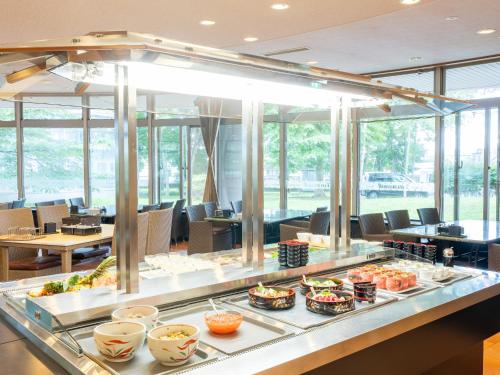 a buffet line with food on display in a restaurant at LiVEMAX Resort Upopoi Shiraoi Onsen in Shiraoi