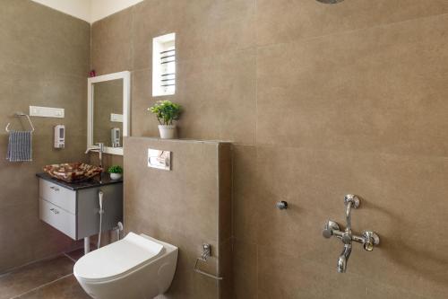 a bathroom with a toilet and a sink at Mistyblue Suites in Bengaluru