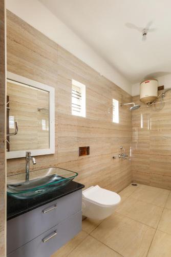 a bathroom with a sink and a toilet at Mistyblue Suites in Bengaluru
