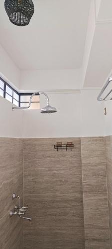 a bathroom with a shower with a shower head at A La Maison in Shillong