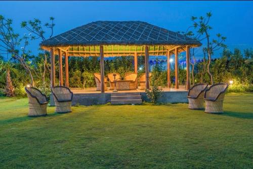a gazebo with chairs in a yard at night at MST Farm And Resort in Ghaziabad