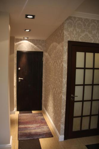 a black door with a rug in a hallway at President Apartments by WarsawResidence Group in Warsaw