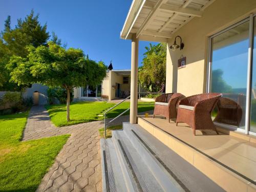 a porch with wicker chairs on a house at Kliprand Guest House in Springbok