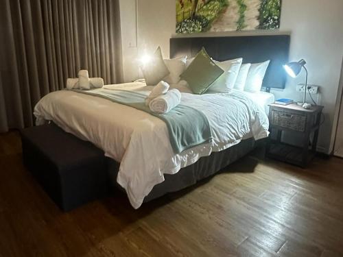 a bedroom with a large bed with towels on it at Kliprand Guest House in Springbok