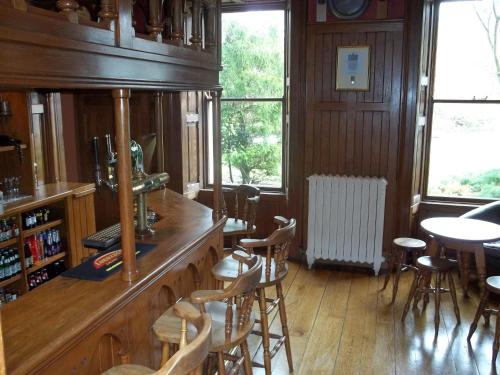 a room with a bar with chairs and a table at Raheen House Hotel in Clonmel