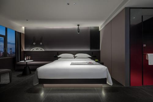 Postel nebo postele na pokoji v ubytování ENJI S Shancheng Designer Hotel