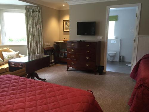 
a hotel room with a bed and a television at Gleann Fia Country House in Killarney

