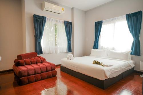 ein Schlafzimmer mit einem Bett und einem Stuhl in der Unterkunft 906 Bangkok City Center Single Pool Villa BTS Asok 5 Bedrooms 6 Bathrooms in Bangkok