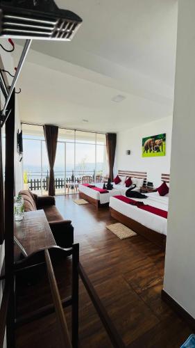 a large room with three beds and a couch at Mountain Paradise Bliss Guest House in Haputale