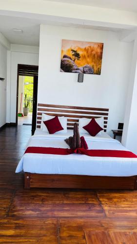 a bedroom with a large bed with red pillows at Mountain Paradise Bliss Guest House in Haputale