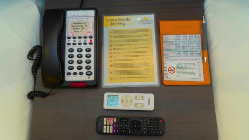 a desk with a calculator and a remote control at Venus Royale Hotel in Coron