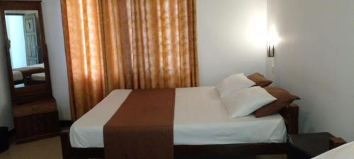 a bedroom with a bed with white sheets and pillows at Samudra Luxe Resort in Habarana