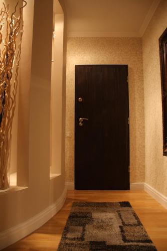 a black door in a room with a rug at President Apartments by WarsawResidence Group in Warsaw