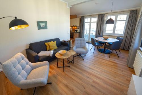 ein Wohnzimmer mit einer Couch und Stühlen und einem Tisch in der Unterkunft Villa Seerose - Appartement 11 in Ostseebad Sellin