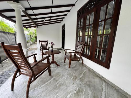 a patio with chairs and a table on a porch at Seahorse Villa in Galle