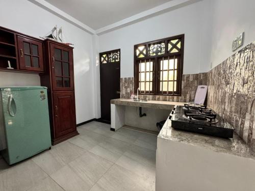 a kitchen with a green refrigerator and a counter top at Seahorse Villa in Galle