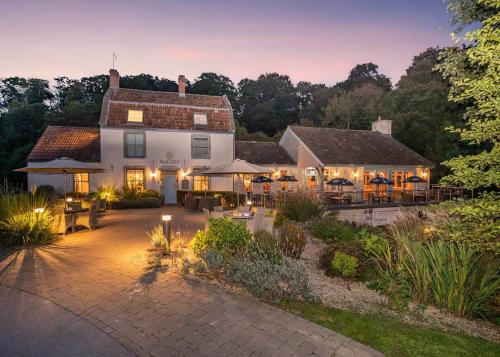 a large white house with tables and umbrellas at Bath Mill Lodge Retreat in Bath