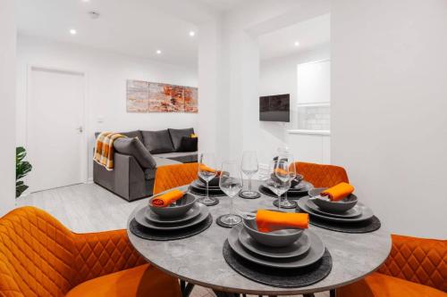 a dining room with a table and orange chairs at Brighton Apt - 2 Bedroom Free Wi-Fi & Parking in Wallasey