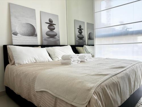 a bedroom with a bed with two towels on it at Enjoy a Modern and Trendy apartment in the Heart of Dubai in Dubai