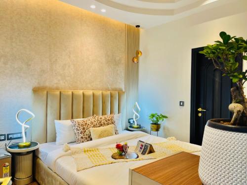 a bedroom with a bed and a table with a plant at Bedchambers, Saket in New Delhi