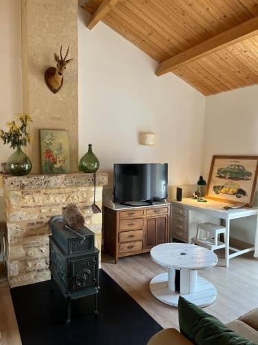 a living room with a stove and a table at Maison de charme - piscine - coeur du Périgord ! in Saint-Georges-de-Blancaneix