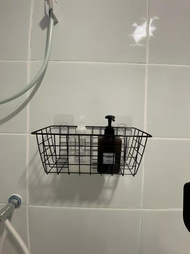 a basket on the wall of a shower in a bathroom at XX GO INN BTS Ari - BTS Ari Station in Sathani Sam Sen