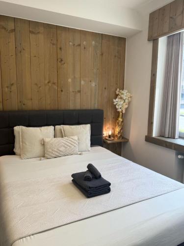 a black remote control sitting on top of a bed at Vernieuwde kamers in het centrum van Brugge in Bruges