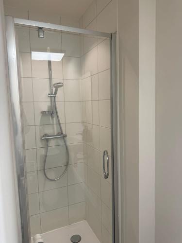 a shower with a glass door next to a toilet at Vernieuwde kamers in het centrum van Brugge in Bruges