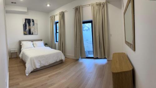 une chambre blanche avec un lit et une fenêtre dans l'établissement Modern, New 3 bed, 2 bath Apt near Manhattan, à Jersey City