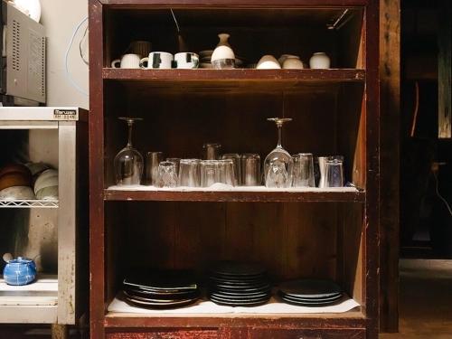 a shelf with plates and glasses in a cabinet at GOYADO in Ozu
