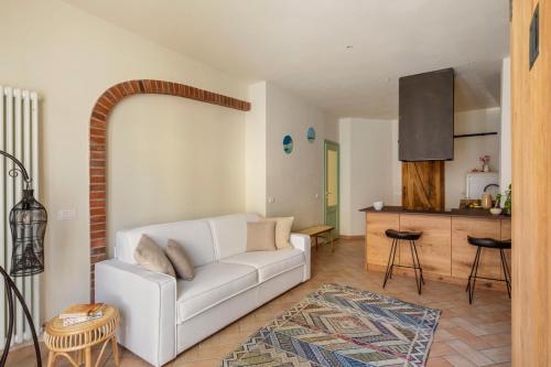 a living room with a white couch and a kitchen at Casa Paolina in Viareggio