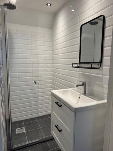 a white bathroom with a sink and a mirror at Sunny Beach in Zandvoort
