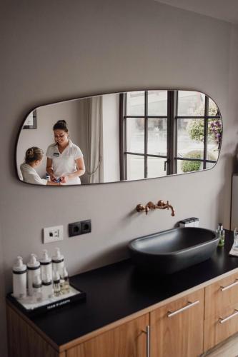 a bathroom with a sink and a mirror at Hotel Seehof Nature Retreat in Naz-Sciaves