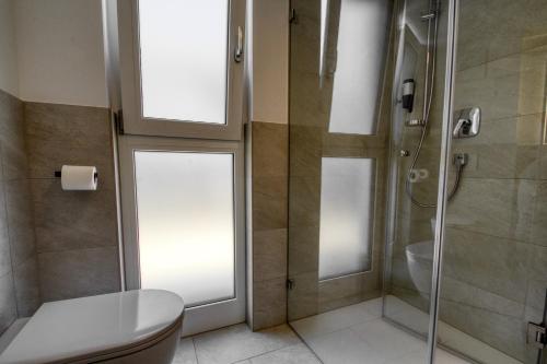 a bathroom with a toilet and a glass shower at myQuartier City Chalets in Innsbruck