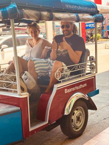 a man and a woman riding in a cart at Baansrisuthum in Don Sak