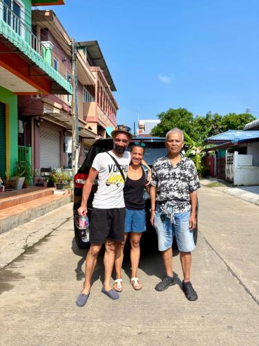 a group of three people standing in front of a car at Baansrisuthum in Don Sak