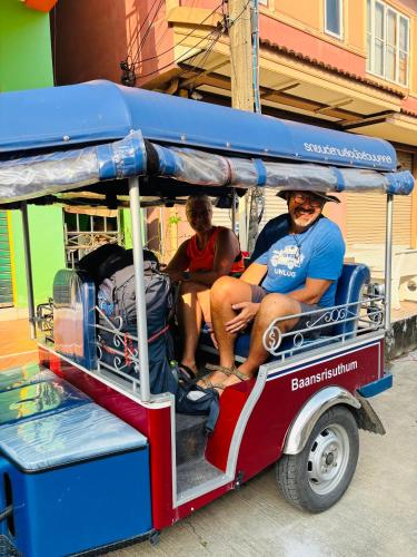 two men are sitting on a small trolley at Baansrisuthum in Don Sak