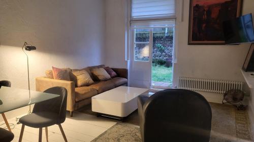 a living room with a couch and a table and chairs at One Bed Garden Flat - Prime location - Free Onsite Parking - Own Entrance in Brighton & Hove