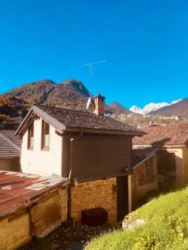 a small white house with mountains in the background at La Bottega del Drago in Santa Brigida